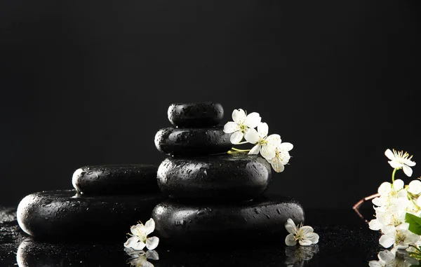 Piedras de spa y flores blancas aisladas en negro — Foto de Stock