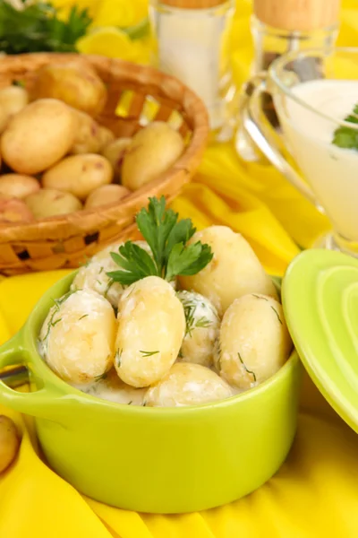 Jeunes pommes de terre tendres à la crème sure et aux herbes dans une casserole sur une table en bois close-up — Photo