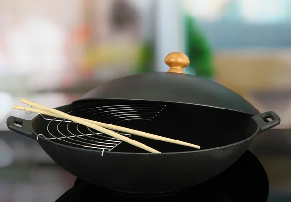 Black wok pan on kitchen oven, close up — Stock Photo, Image