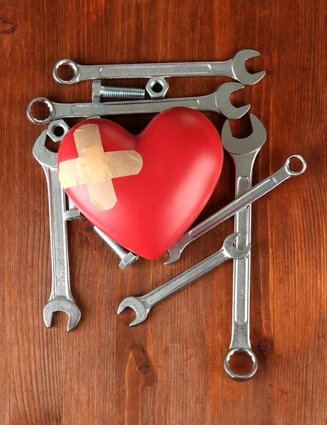 Heart and tools. Concept: Renovation of heart. On wooden background — Stock Photo, Image