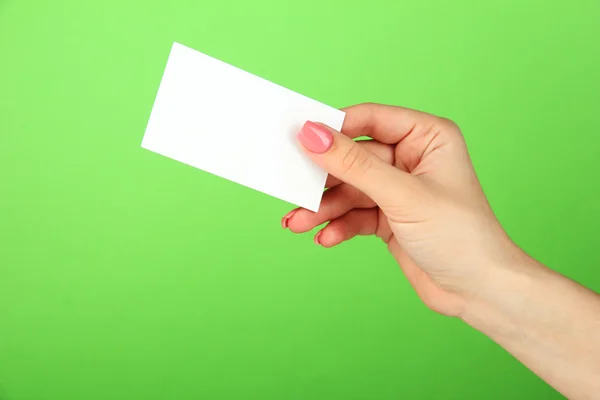 色の背景上のビジネス カードを持っている女性手 — ストック写真