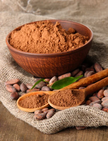 Cacao en polvo y granos de cacao sobre fondo de madera — Foto de Stock