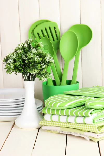 Kitchen settings: utensil, potholders, towels and else on wooden table — Stock Photo, Image