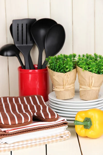 Ajustes de cocina: utensilios, agarraderas, toallas y más en la mesa de madera —  Fotos de Stock