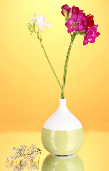 Beau bouquet de freesia en vase sur fond orange — Photo