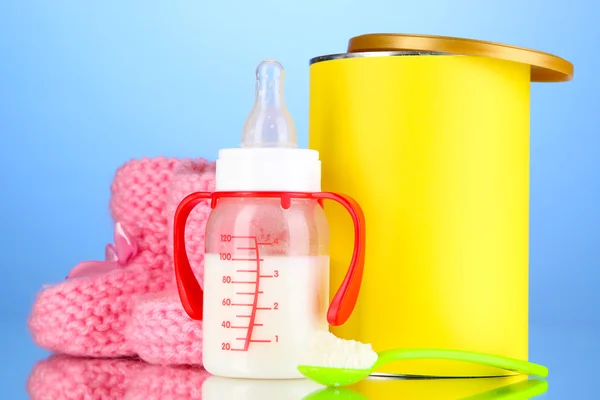 Fles met melk en voedsel voor baby's op blauwe achtergrond — Stockfoto