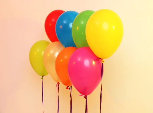 Veel heldere ballonnen op oranje achtergrond — Stockfoto