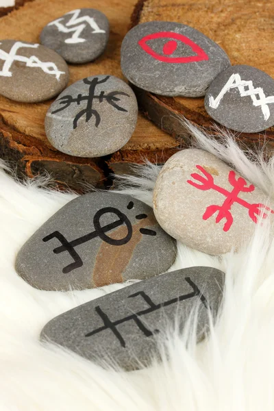 Věštectví symboly na kamenech na pozadí bílé kožešiny — Stock fotografie