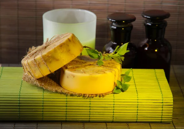 Sabão feito à mão e ingredientes para fabricação de sabão no fundo da esteira de bambu — Fotografia de Stock