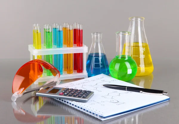 Test-tubes with colorful liquids on gray background — Stock Photo, Image