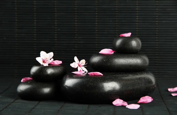 Spa kamienie i kwiaty na tle bambusa — Zdjęcie stockowe