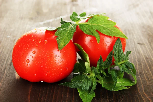 Fresh tomatoes on wooden table close-up — Stock Photo, Image