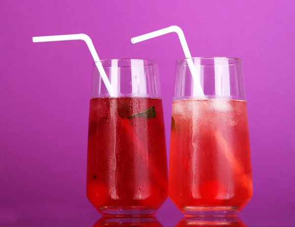 Дві вишневі коктейлі з льодом на фіолетовому фоні — стокове фото