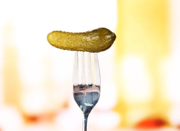 Concombre en conserve collant sur la fourchette, sur fond lumineux — Photo