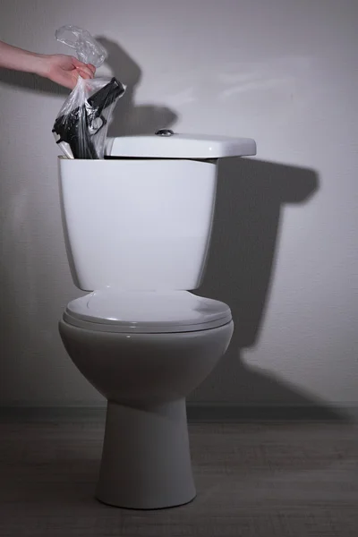 Kézi elrejti a fegyvert és pénzt egy fürdőszoba WC tartály — Stock Fotó