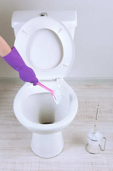 Vrouw hand met borstel schoonmaak een wc-pot in een badkamer — Stockfoto