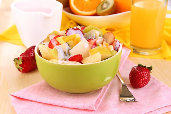 Salada de frutas útil de frutas frescas e bagas em tigela em guardanapo em mesa de madeira close-up — Fotografia de Stock