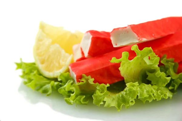 Krabbenstangen auf Salatblättern mit Zitrone, isoliert auf weiß — Stockfoto