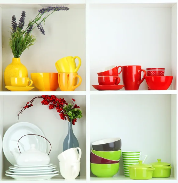 Beautiful white shelves with tableware and deco — Stock Photo, Image