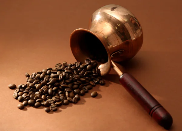 Cafetière avec grains de café sur fond brun — Photo