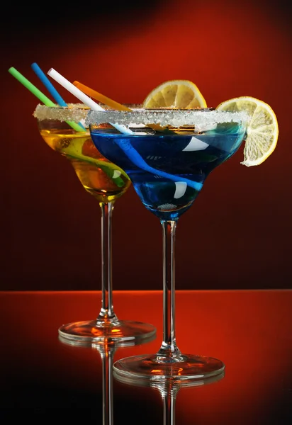 Cocktails jaunes et bleus dans des verres sur fond de couleur — Photo