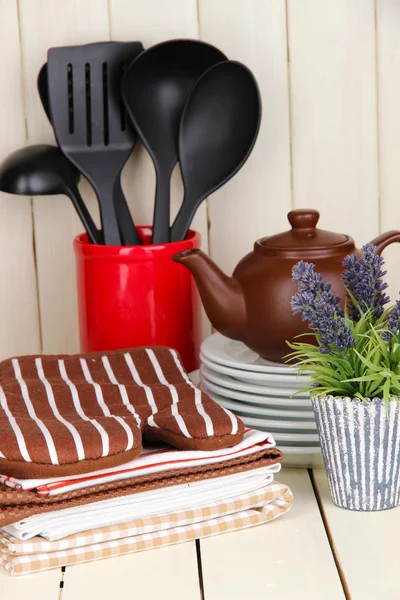 Кухонные принадлежности: посуда, выбоины, полотенца, а также на деревянном столе — стоковое фото