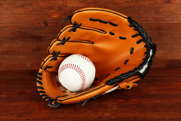 Luva de beisebol e bola no fundo de madeira — Fotografia de Stock
