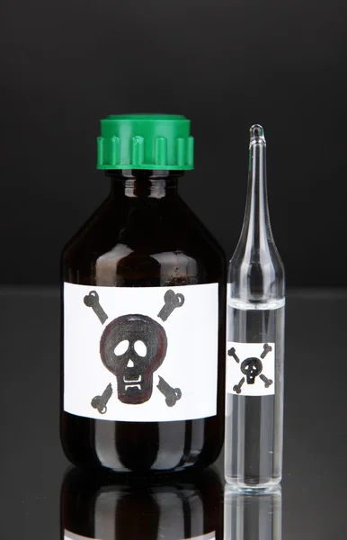 Смертельный яд в бутылках на черном фоне — стоковое фото