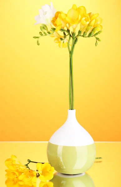 Beautiful bouquet of freesia in vase on orange background — Stock Photo, Image