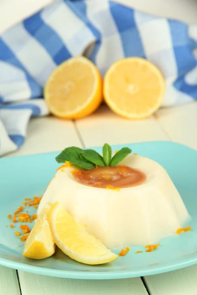 Panna al limone Cotta con scorza d'arancia e salsa al caramello, su fondo di legno a colori — Foto Stock