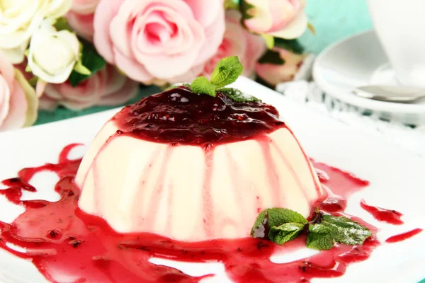 Panna cotta mit Himbeersoße, auf farbigem Holzhintergrund — Stockfoto