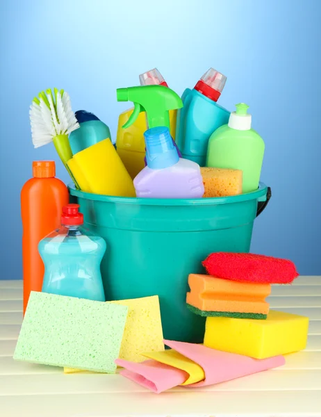 Reinigungsartikel im Eimer auf farbigem Hintergrund — Stockfoto