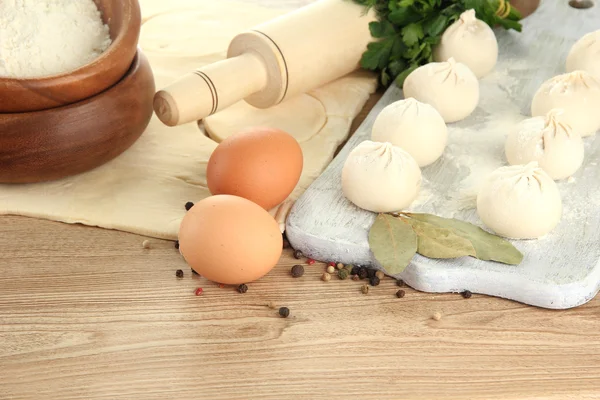 Raw dumplings, ingredients and dough, on wooden table — Stock Photo, Image