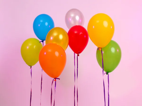 Viele helle Luftballons auf rosa Hintergrund — Stockfoto