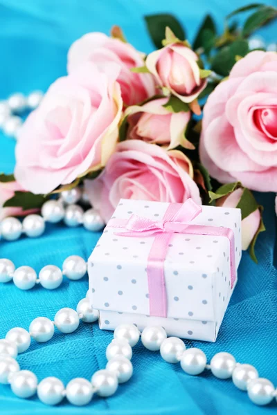 Rose en gift op blauw doek — Stockfoto