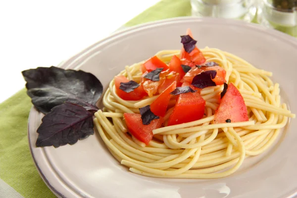 Spaghetti con pomodori e foglie di basilico su tovagliolo isolato su bianco — Foto Stock