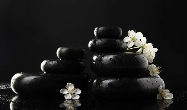 Piedras de spa y flores blancas aisladas en negro — Foto de Stock