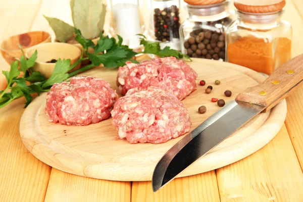 Raw meatballs with spices on wooden table — Stock Photo, Image