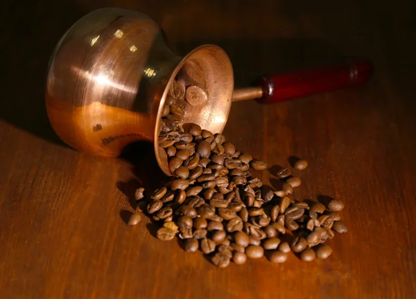 Cafetera con granos de café sobre fondo de madera marrón — Foto de Stock