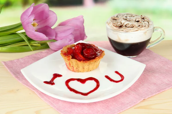 Sweet cake with strawberry and sauce on plate, with coffee, on bright background — Stock Photo, Image