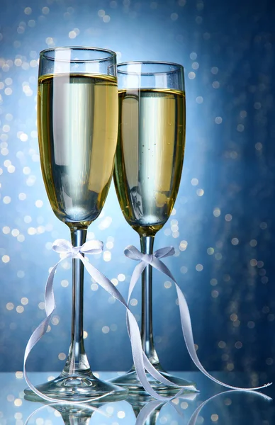 Två glas champagne på ljus bakgrund med ljus — Stockfoto