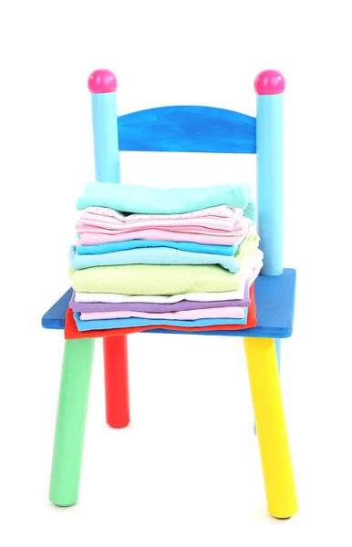Маленький и цветной стул с детской одеждой, изолированной на белом — стоковое фото