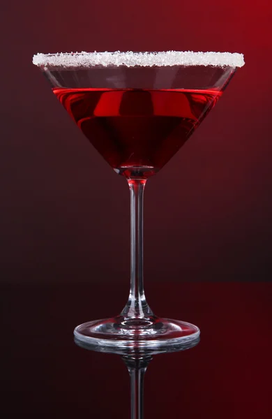 Red cocktail in martini glass on dark red background — Stock Photo, Image