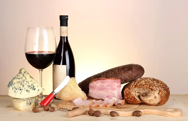 Exquisito bodegón de vino, queso y productos cárnicos — Foto de Stock