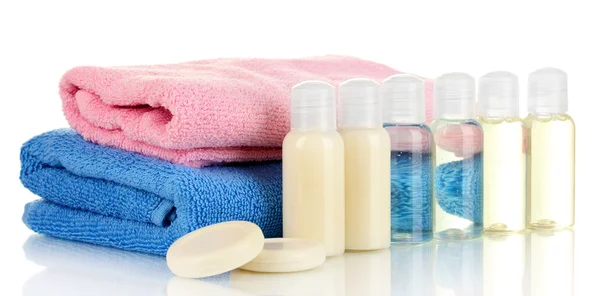 Hotel cosmetic bottles with towel isolated on white — Stock Photo, Image