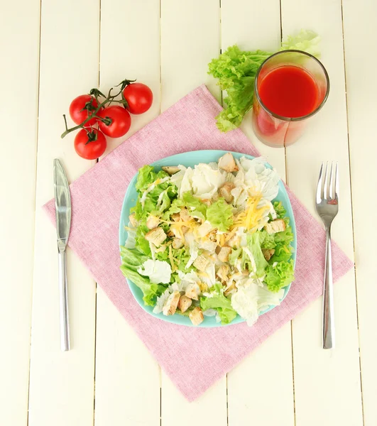 Caesar-Salat auf blauem Teller, auf farbigem Holzhintergrund — Stockfoto