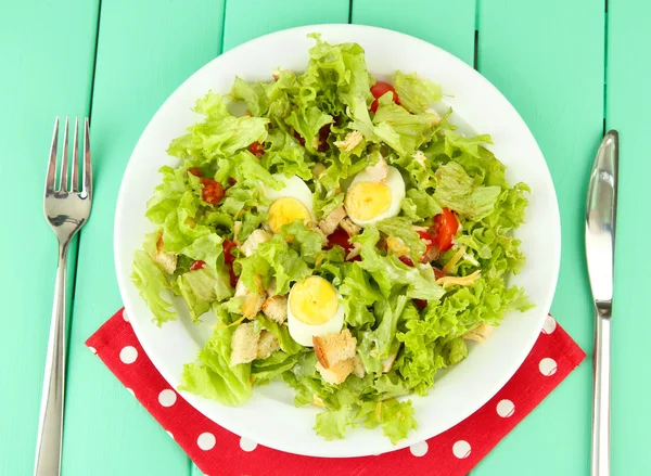 Salade César sur assiette blanche, sur fond de bois couleur — Photo