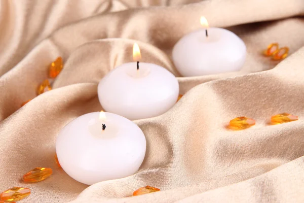 Candles on golden fabric close-up — Stock Photo, Image