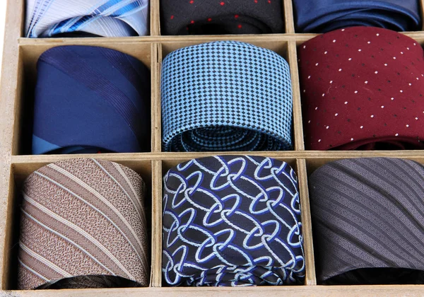 Neckties in wooden box isolated on white — Stockfoto