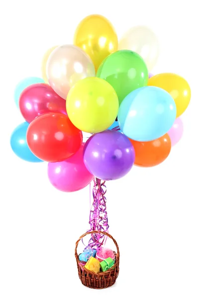 Many bright balloons and basket with gifts isolated on white — Stock Photo, Image